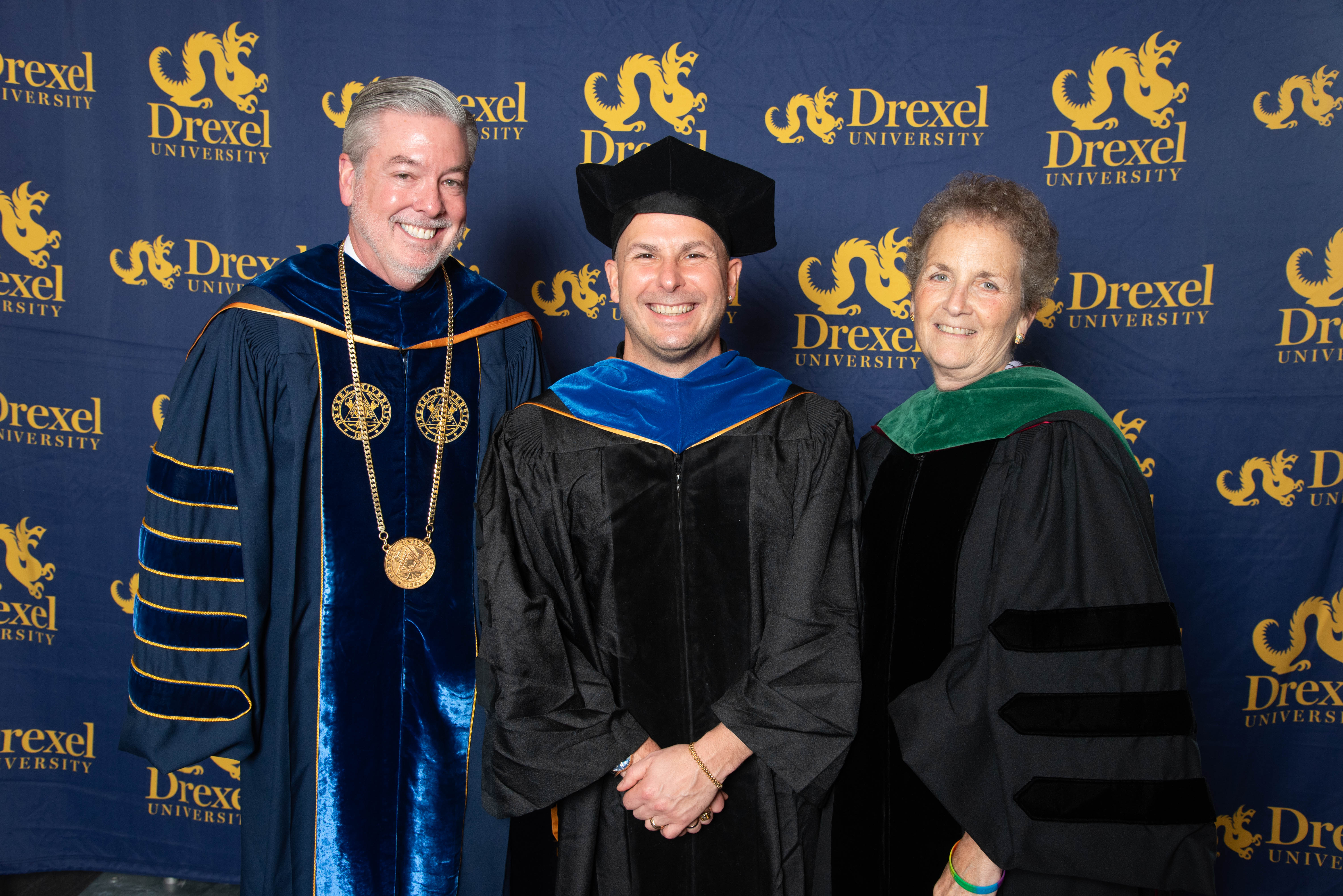 President John Fry, Marla Gold, and Yannick Nézet-Séguin pose for a photo in commencement regalia