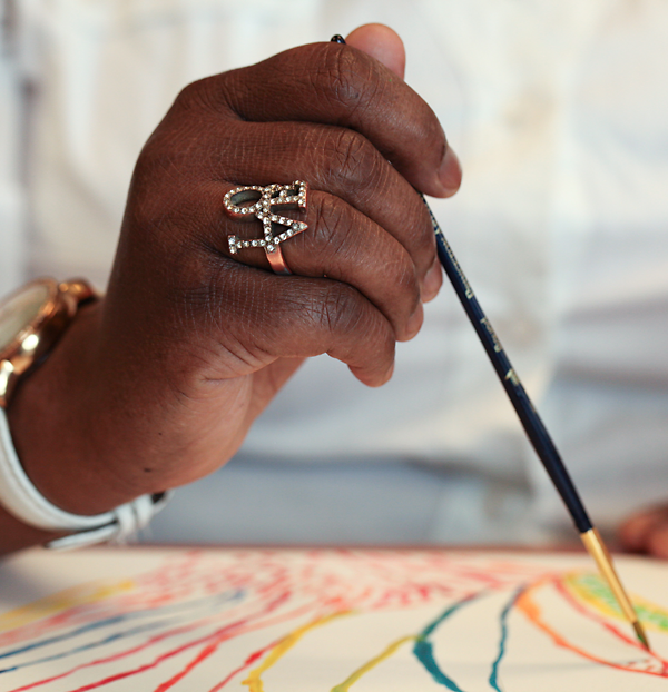 Close-up of a woman's hand, painting as part of a healing-focused effort at Drexel's 11th Street health center. Photo by Lynn Johnson