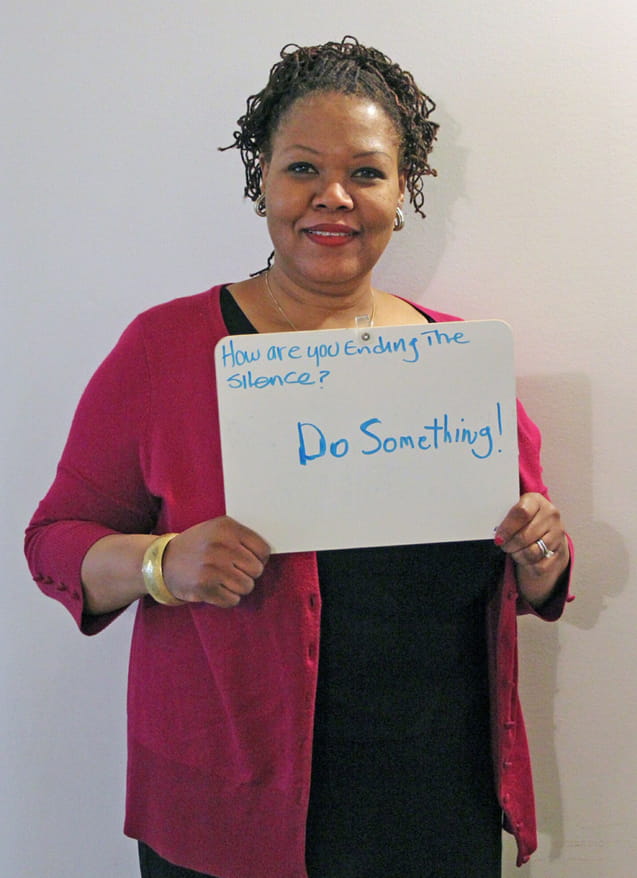 Millie Carvalho-Grevious, PhD, diversity and inclusion coordinator in the Office of Equality and Diversity at Drexel, holding a sign with a message for the National Day of Silence.