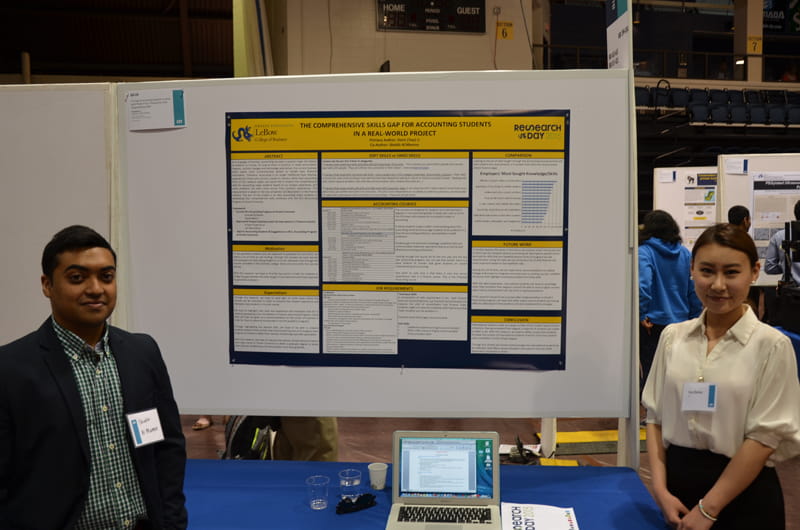 Shaikh Al Mamun (left) and Dori (Yue) Li (right), standing in front of their poster displaying their research on accounting skills students need to compete in the real world.