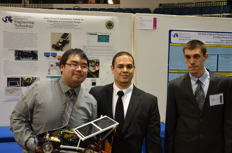 Kingston Lee, Carlos Ruiz and Aurel Mathews (standing left to right) with their prototype automated, solar-powered vehicle.