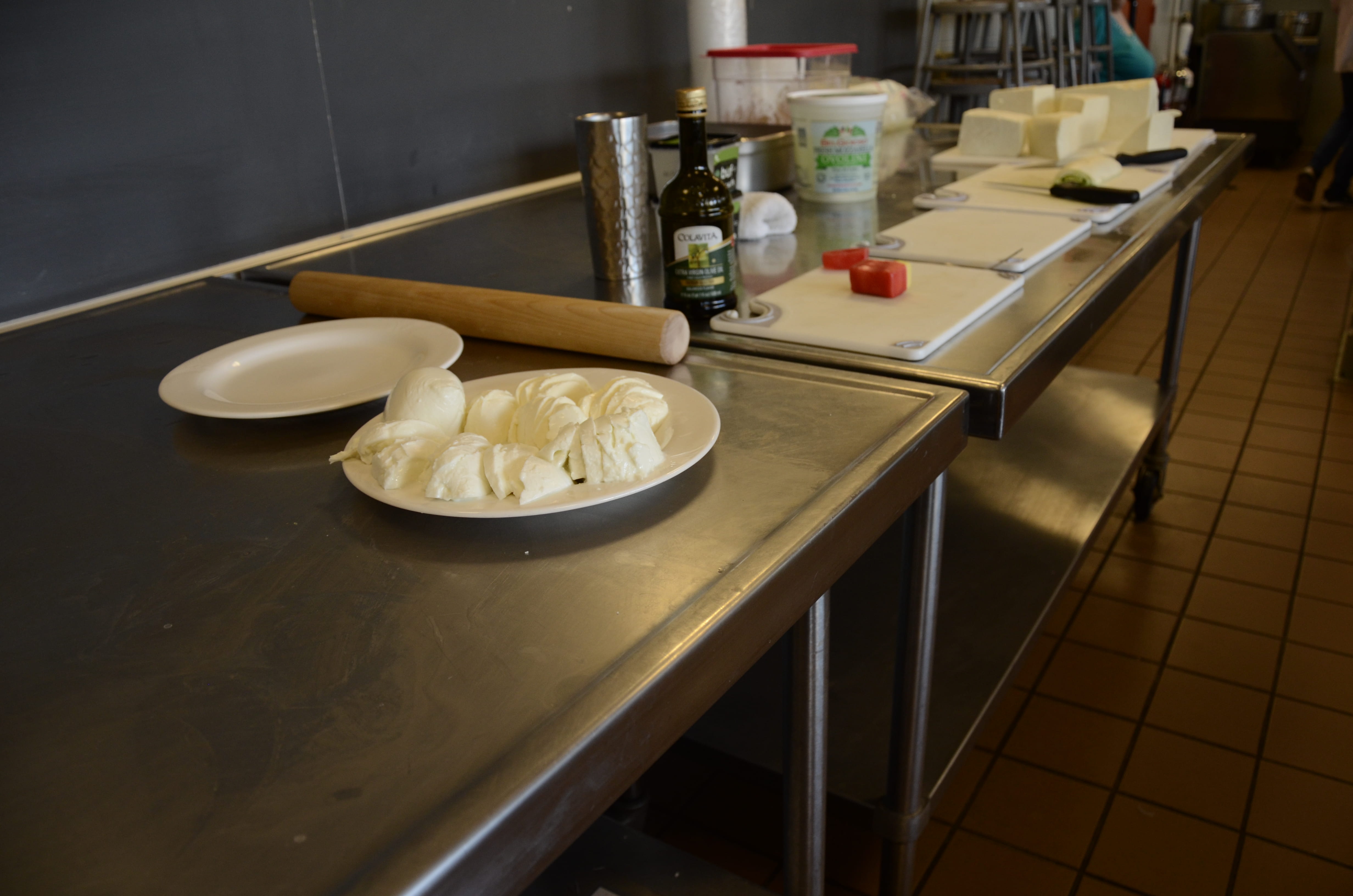 A sample of what the students could taste during the mozzarella-making class, from left to right: store-bought mozzarellas, the waxed cheddar from the last class, a rolled mozzarella with pesto and prosciutto, and the mozzarella that the students would heat, stretch and shape.