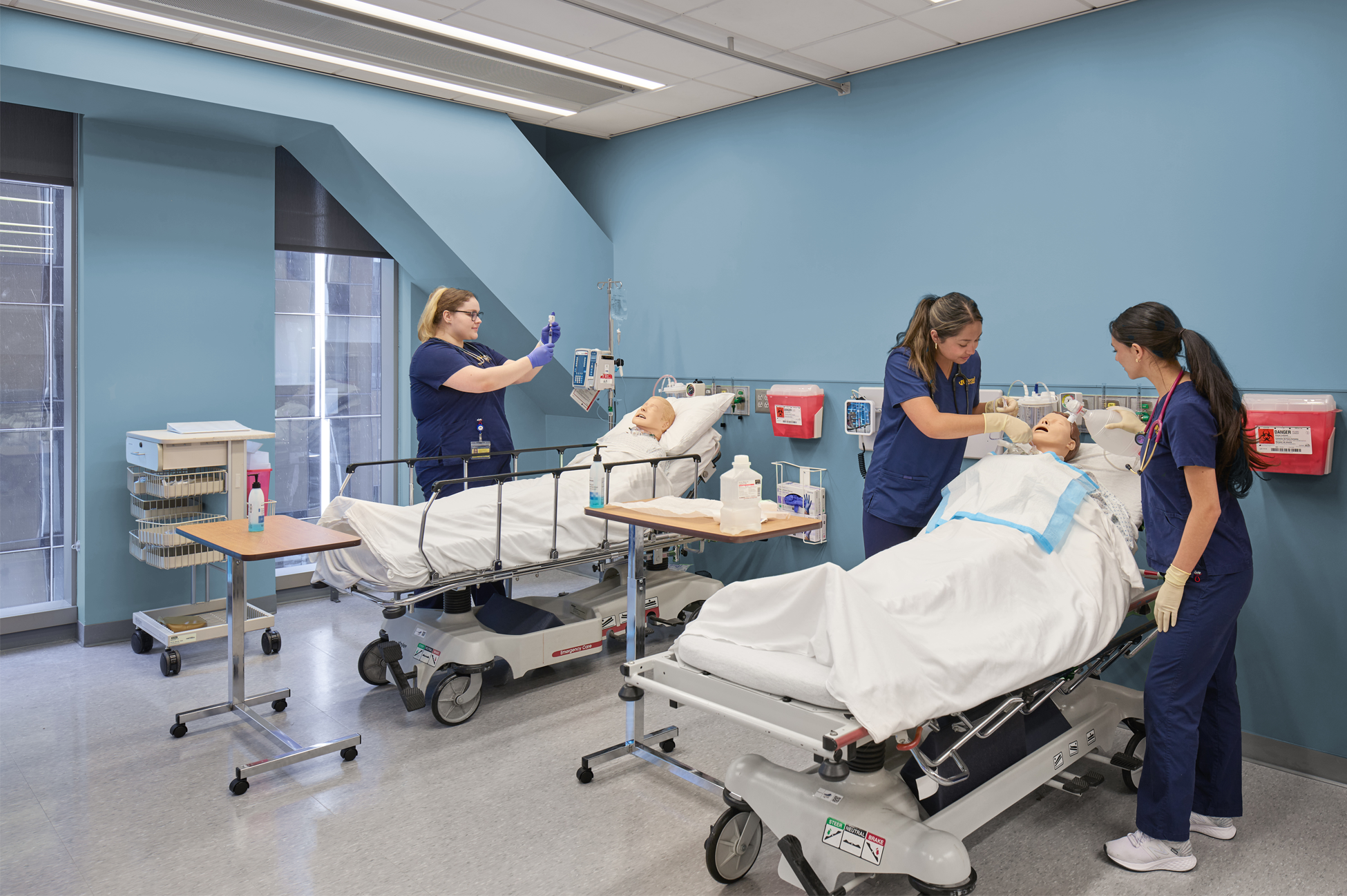 students practice on manikins in hospital beds