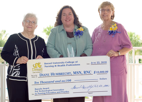 Dean Donnelly presents check with 2 nursing professionals