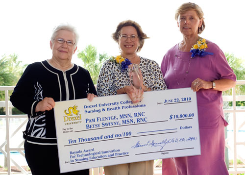 Dean Donnelly presents check with 2 nursing professionals