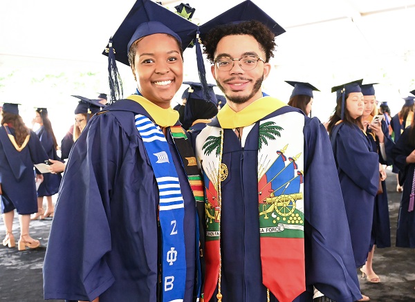 Two people wearing Drexel University caps and gowns