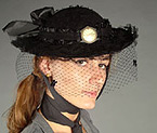 Model wearing a black hat with netted veil