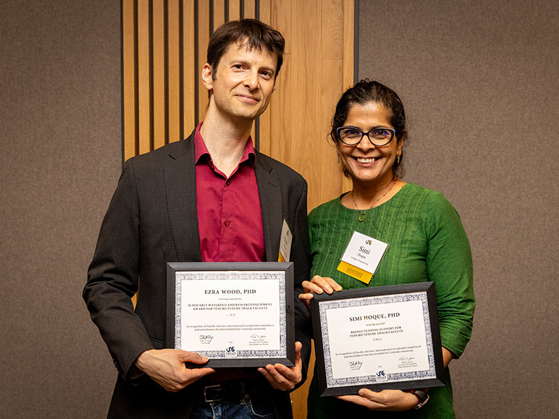 A man and a woman holding award certificates