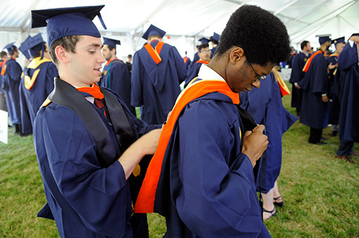 Graduates assist one another in preparing.