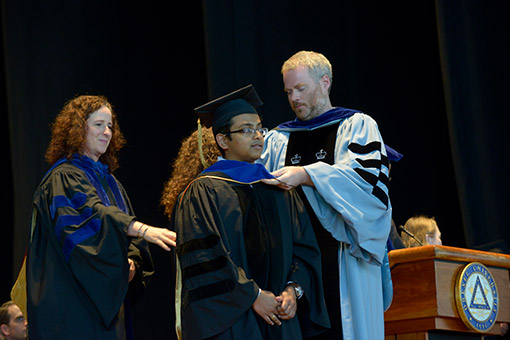 Graduate students receive their hoods.