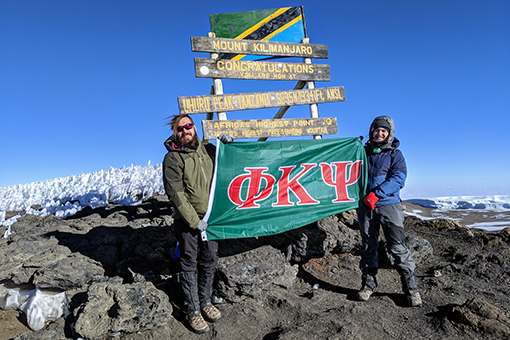 Leap and Cohen hold a flag representing their fraternity, Phi Kappa Psi, at Uhuru Peak.