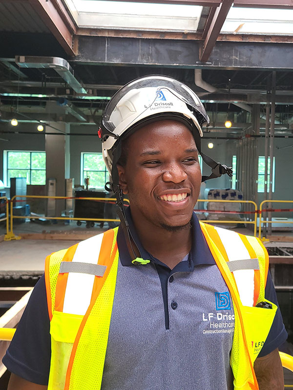 Young Black man in hard hat and safety vest at construction site