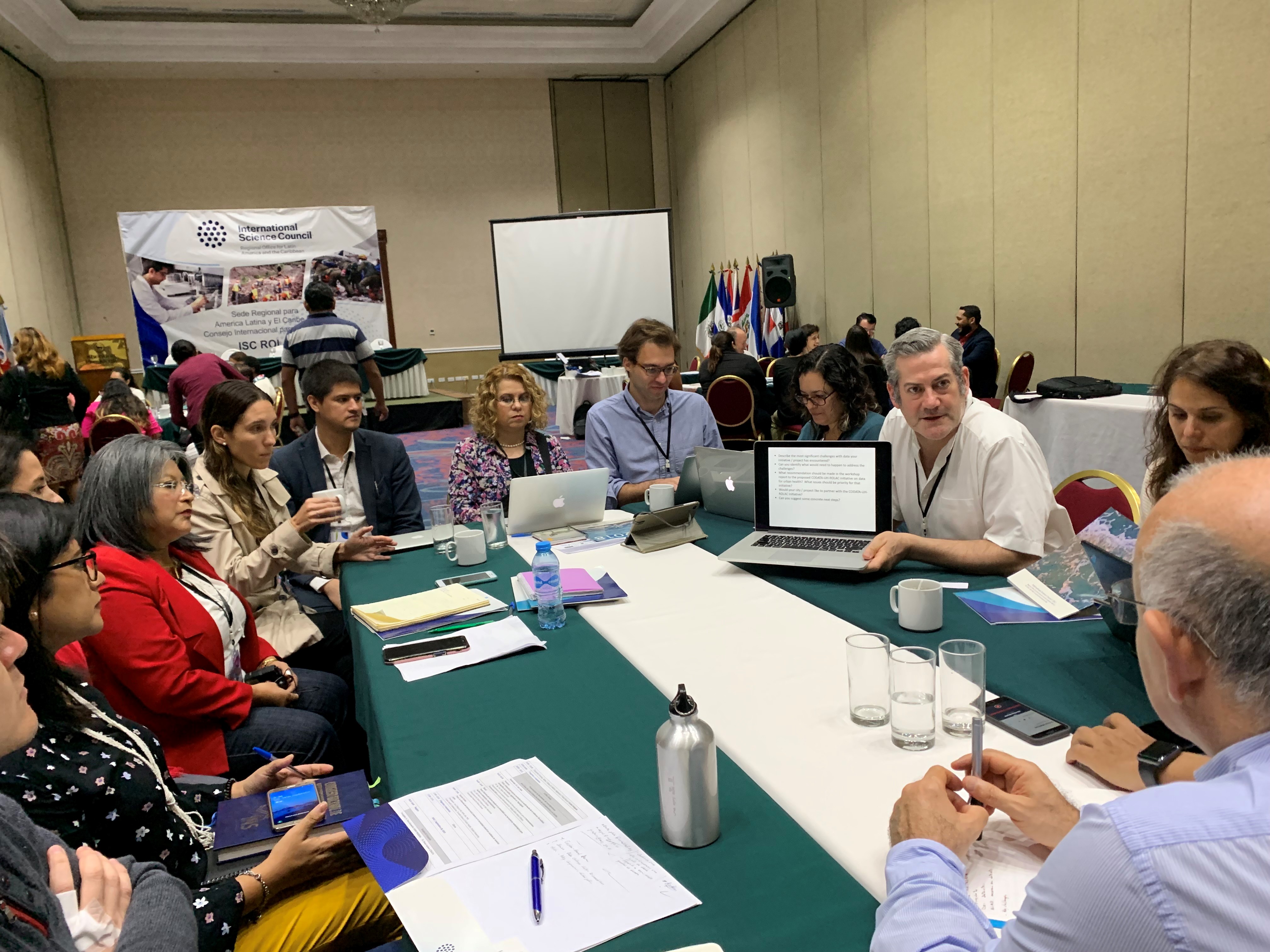 researchers at table discussing health data in latin america