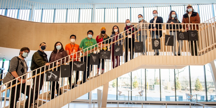 The students who attended the Dispassionate Observation event standing on a staircase with their drawings