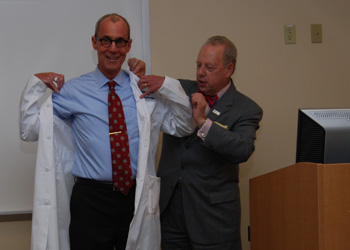 Daniel V. Schidlow, MD, Annenberg Dean of Drexel University College of Medicine, presents a Drexel white coat to Richard Sloan, MD, director of medical education at WellSpan York Hospital