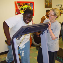 Boy on treadmill with PT trainer