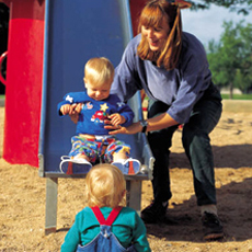 mother and toddlers on slide