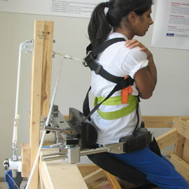 Woman in device testing back strength.