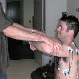PT researcher testing man's shoulders.