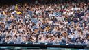 Students in Commencement regalia, some with ponchos and umbrellas, in the stands of Citizens Bank Park for Drexel's 2024 Commencement.