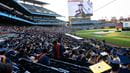 View of the Commencement with a speaker wearing a decorated cap and decorated caps in the stands.