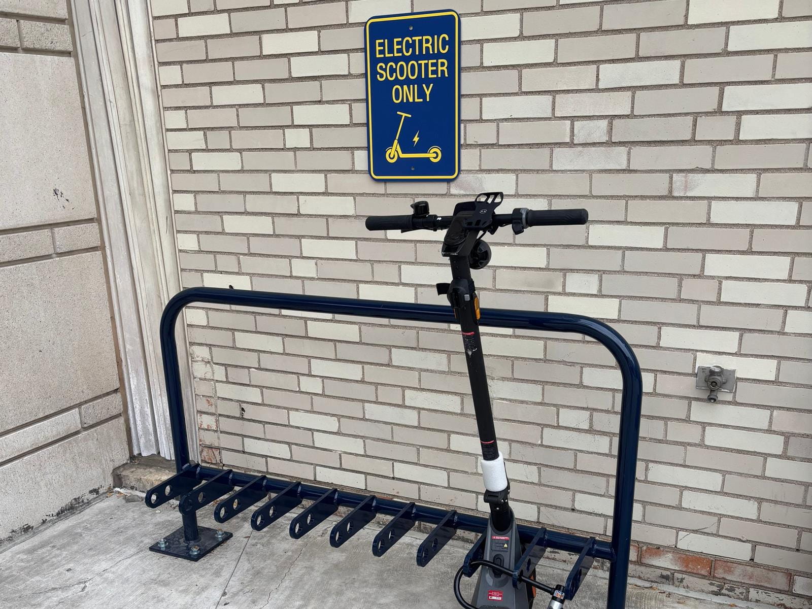 photo of scooter parking sign and rack