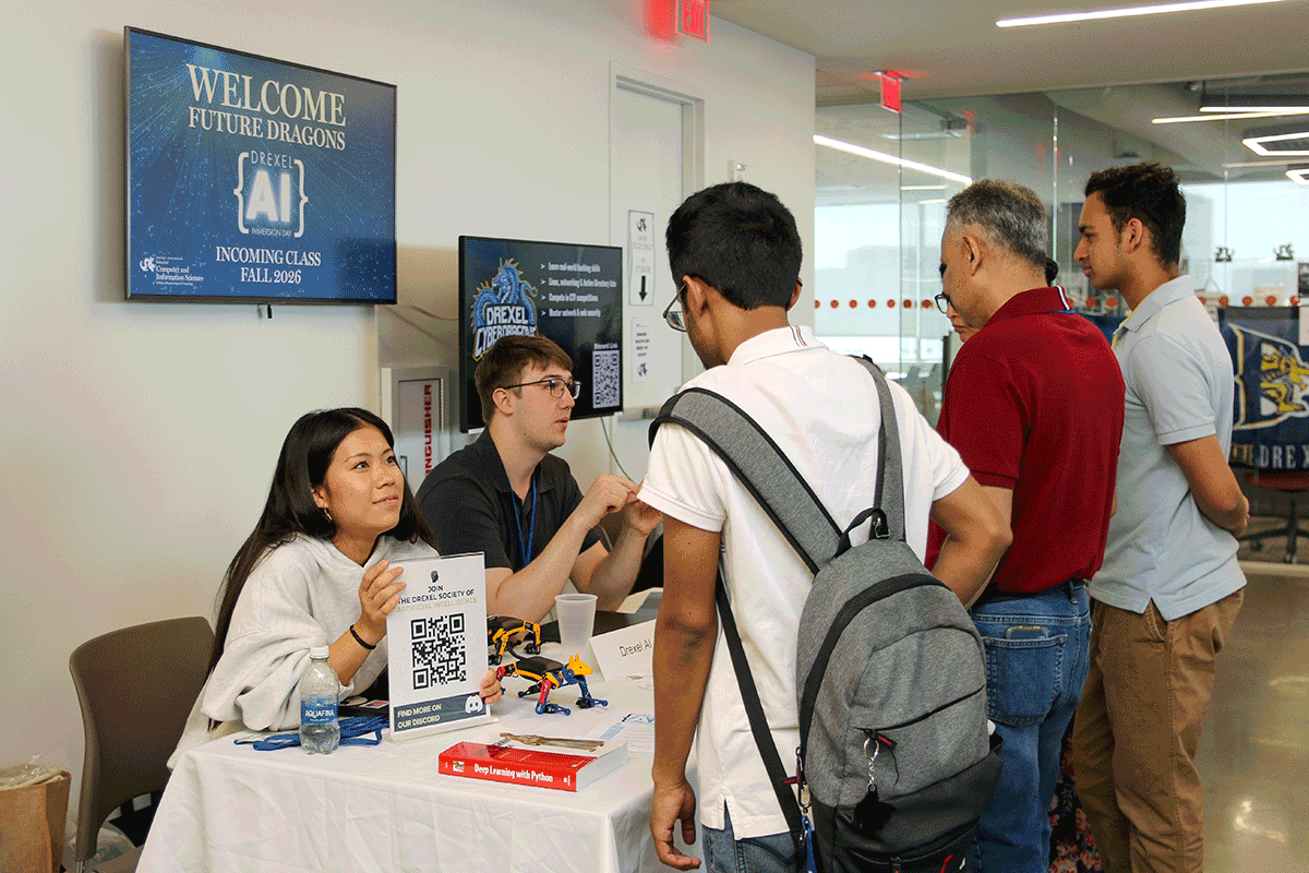 Two Drexel students speaking with attendees of the event