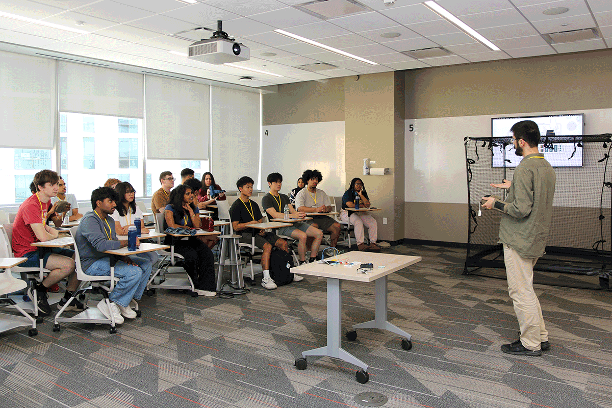 Attendees sitting in a classroom with a professor at the front