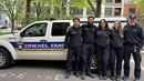 Five student EMS workers in front of a EMS automobile.