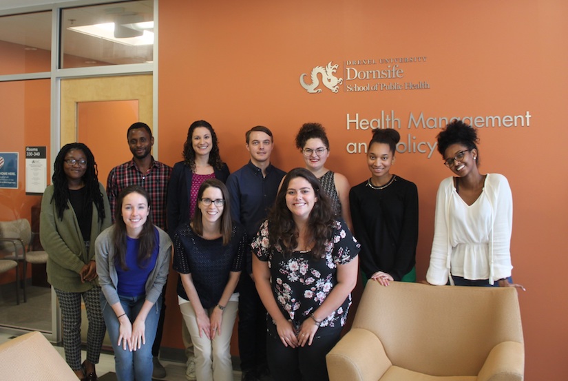 MPH students stand in front of Dornsife's Health Management and Policy department sign