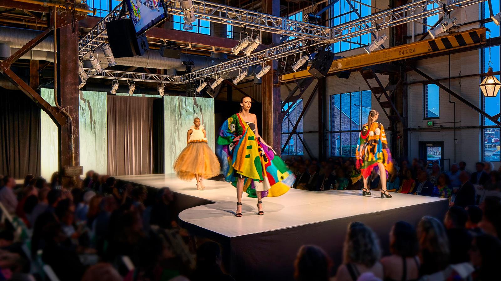 Models wearing student fashions and walking on a runway