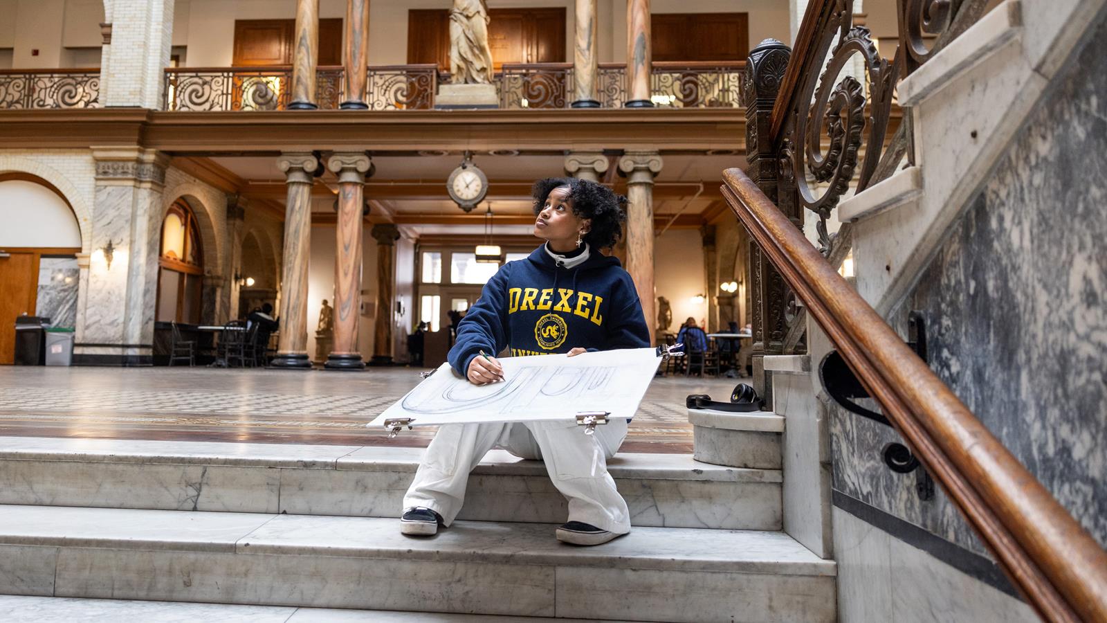 Westphal student drawing in Drexel's Main Building
