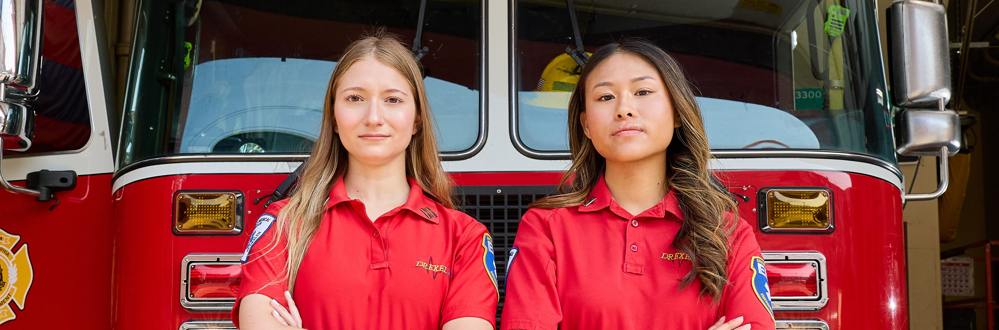 Students in EMS uniforms standing in front of a fire truck