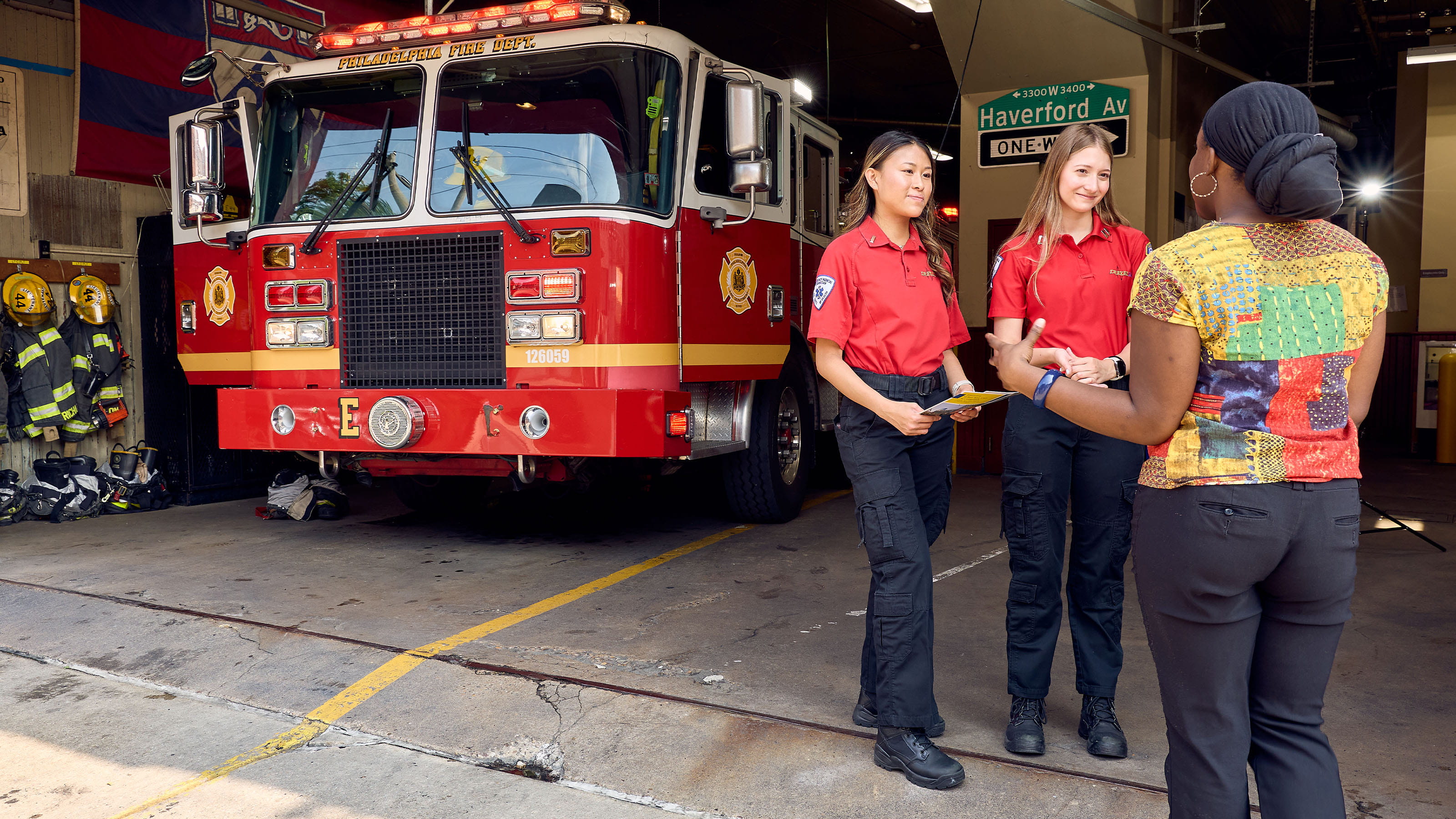 Students in EMS uniforms standing in front of a fire truck