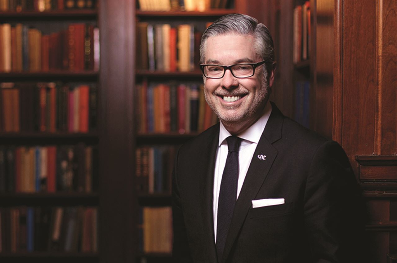 photo of president Fry in front of book library