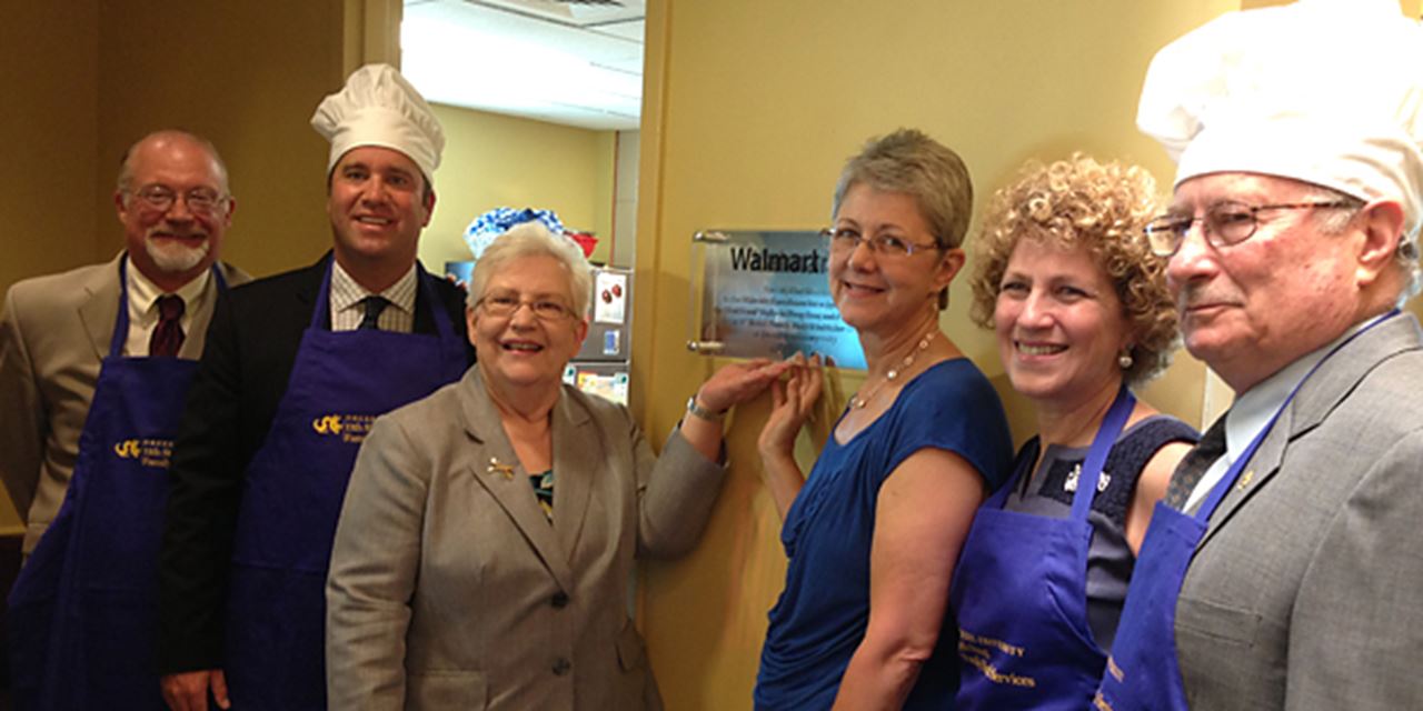 City Council Representative William Greenlee, Walmart representative Jason Klipa, Dr. Gloria Donnelly, Dr. Patty Gerrity, Sandy Sheller and Steve Sheller unveil a plaque at 11th Street.