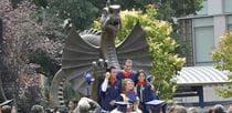 Photo of graduating students in front of Dragon Park Statue