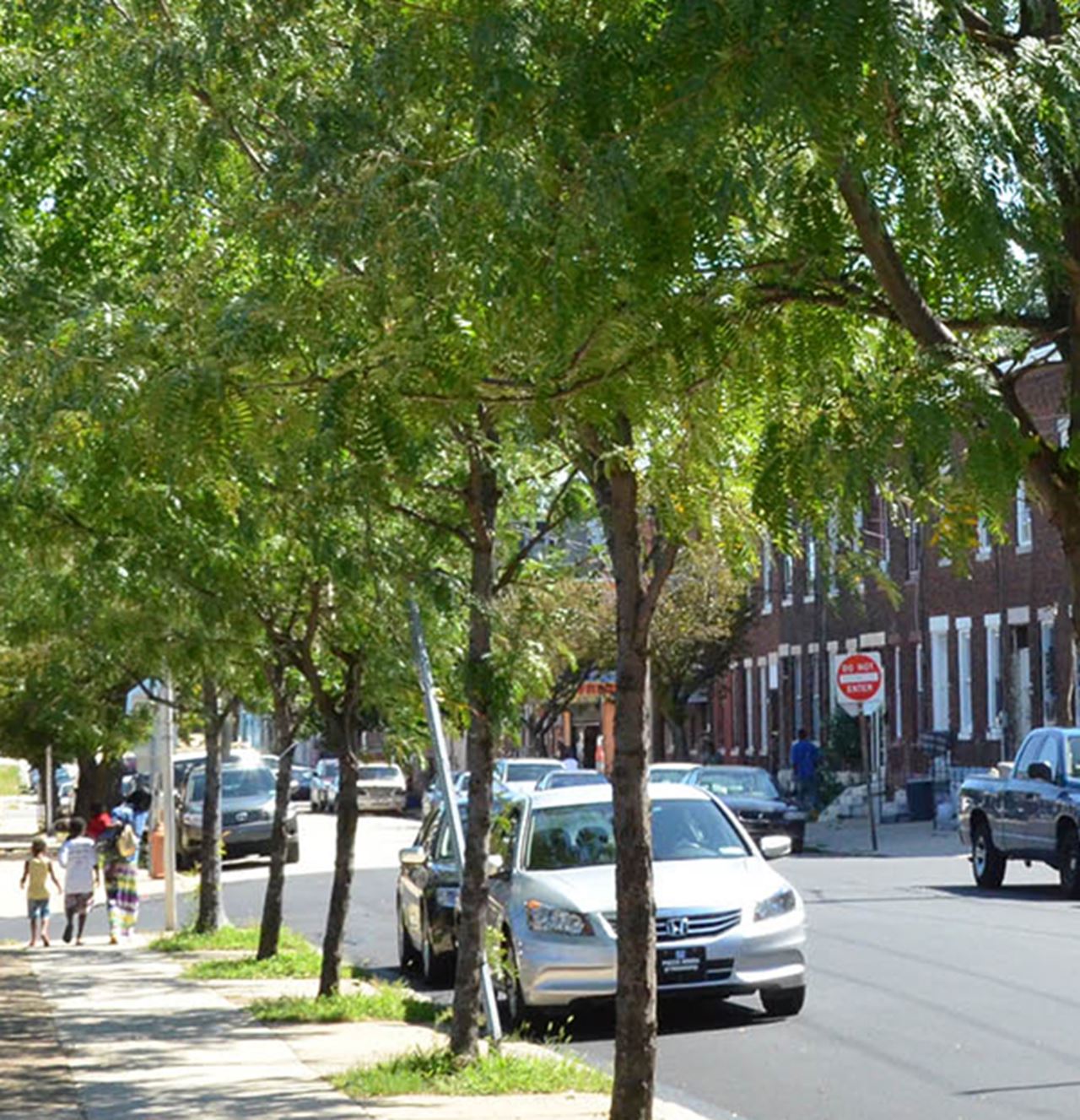 A family walks in an urban neighborhood, Powelton Village, near Drexel University in Philadelphia.