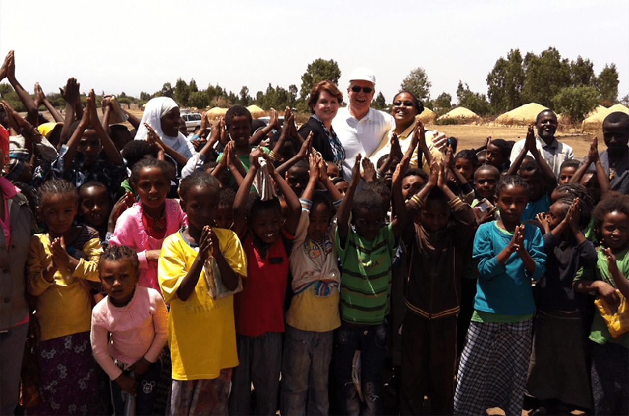 Dana and David Dornsife and Shannon Marquez, PhD, with children and friends at Kechema Water Point in Ethiopia, a World Vision WASH project site.