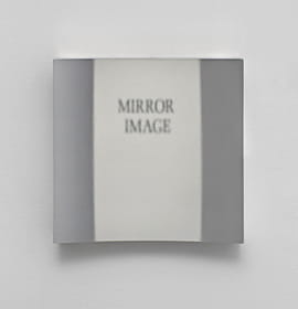 The words "mirror image" are reflected, but not reversed, in this photo of the Hicks non-reversing mirror taken at Robin Cameron's art show. Photo courtesy Room East in New York.