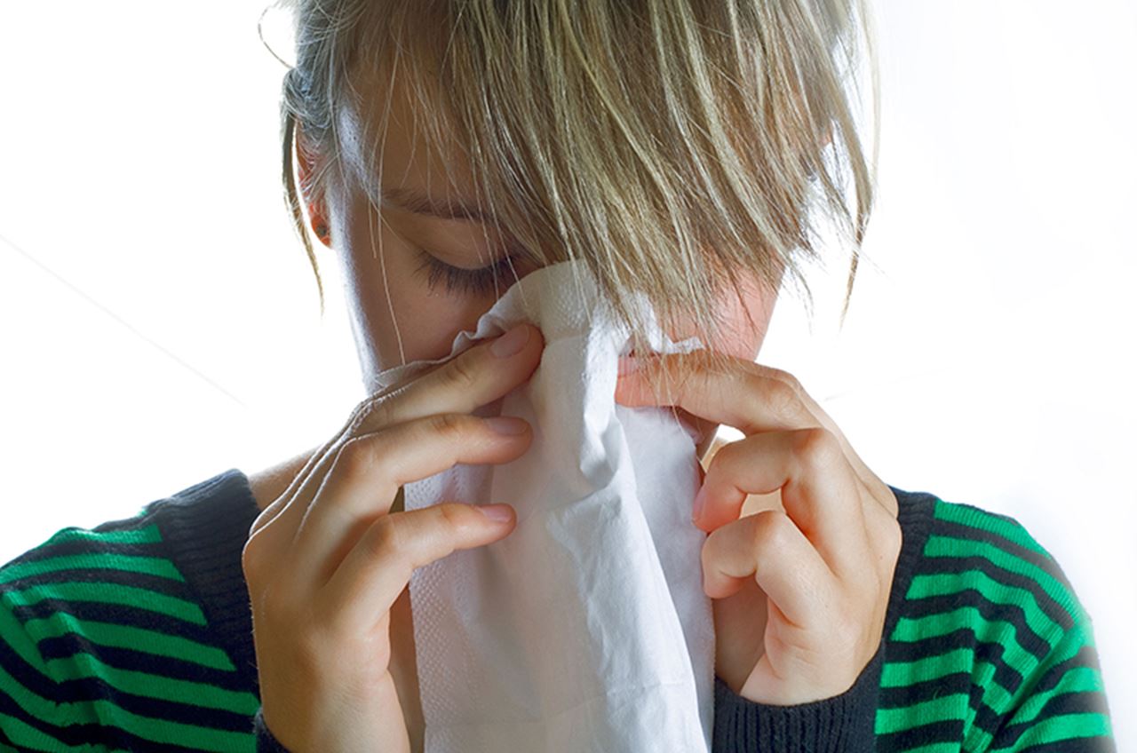 Woman blowing her nose