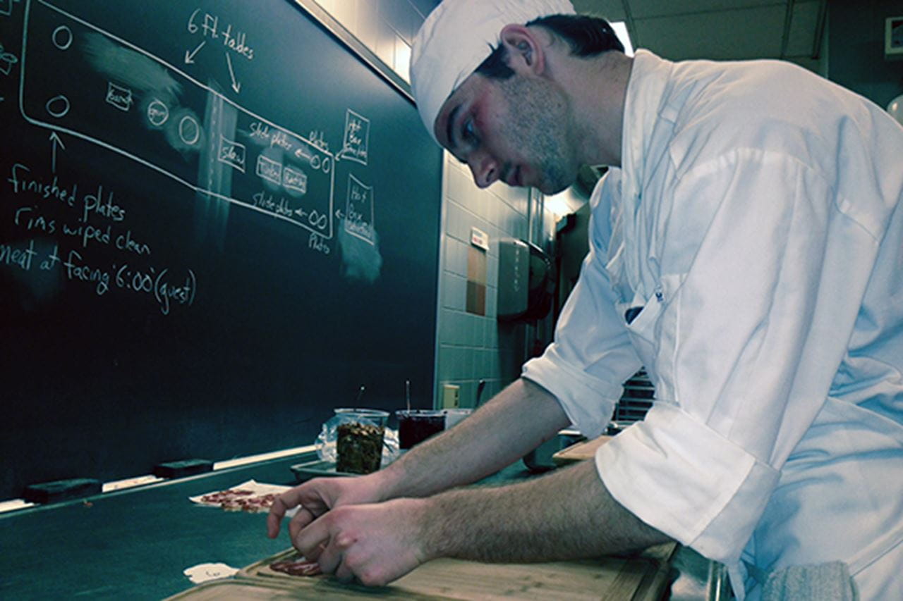 Chef arranging salami slices
