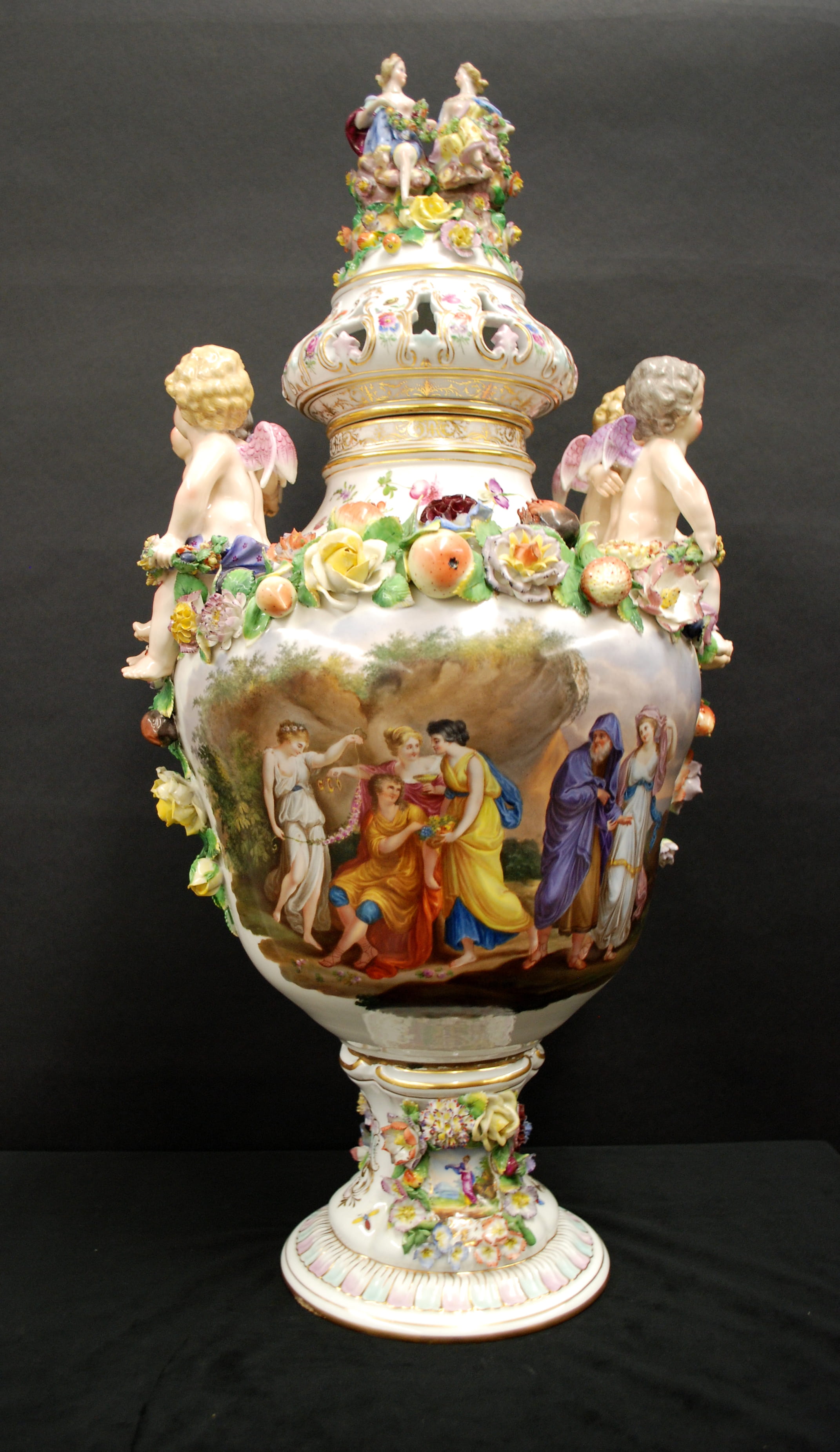 A close up of Drexel's Meissen imitation urn, which features several distinctly Meissen elements like crisply sculpted fruits, the sprays of flowers and small details such as bugs or a single flower.