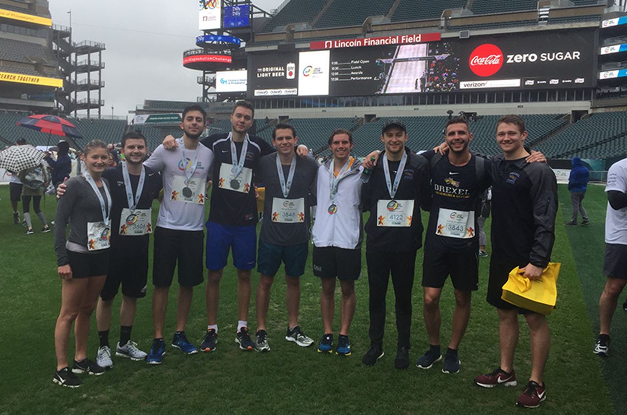 A group of students in Drexel colors lined up on the field at Lincoln Financial Field