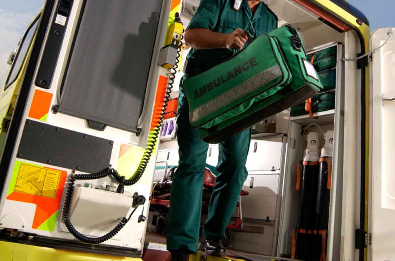An emergency responder exits an ambulance