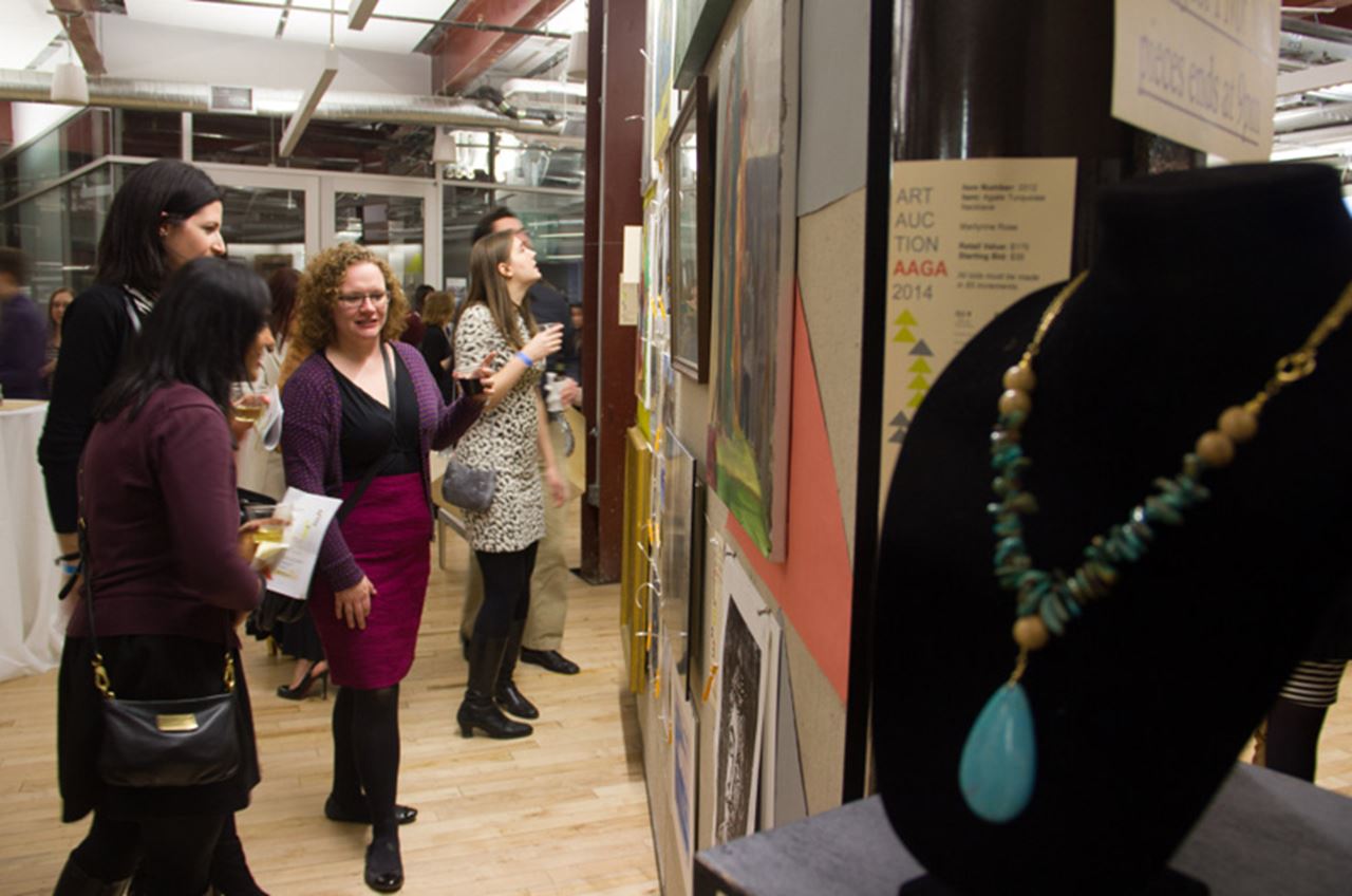 Attendees at last year's art auction looking over some of the available pieces.
