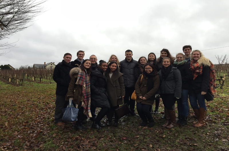 The MGMT 370 course poses in their client's vineyard in France.