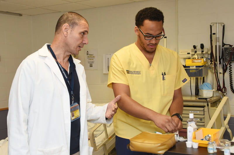 Adjunct faculty member Alfred Giosa working with a Drexel nursing student.