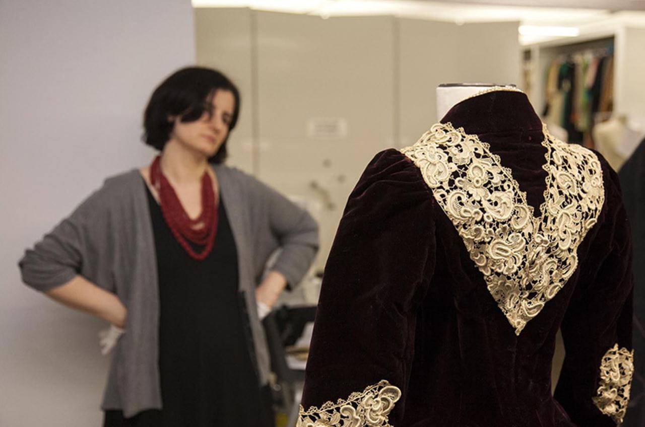 Clare Sauro, curator of the Fox Historic Costume Collection, checking her work on a mannequin for Immortal Beauty. Photo by Michael J. Shepherd.