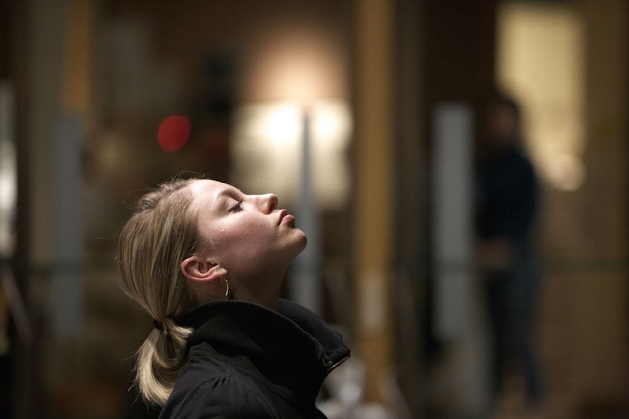 A woman meditating, taking in a breath of fresh air. 